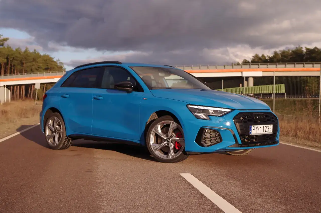 Niebieskie Audi A3 na drodze, z widoczną tablicą rejestracyjną. Jego waga jest optymalna do dynamicznej jazdy.