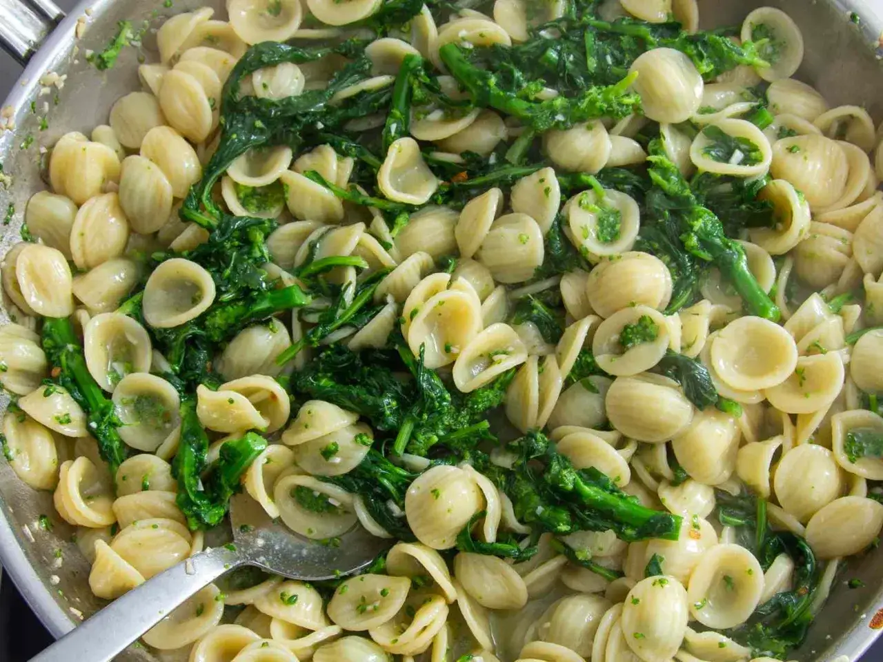 Pyszne danie z makaronem orecchiette i zielonymi warzywami, gotowe do podania.