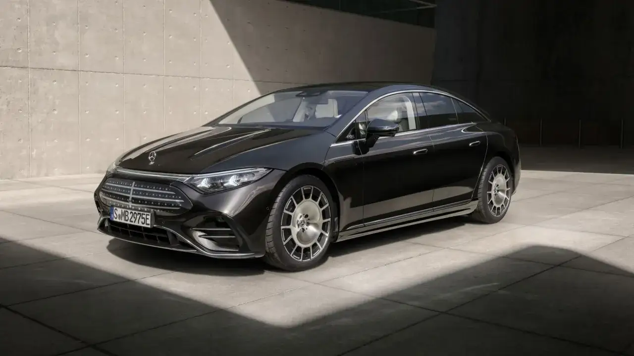 Schwarzer Mercedes-Benz EQS mit Facelift, elegant vor Betonwand geparkt.