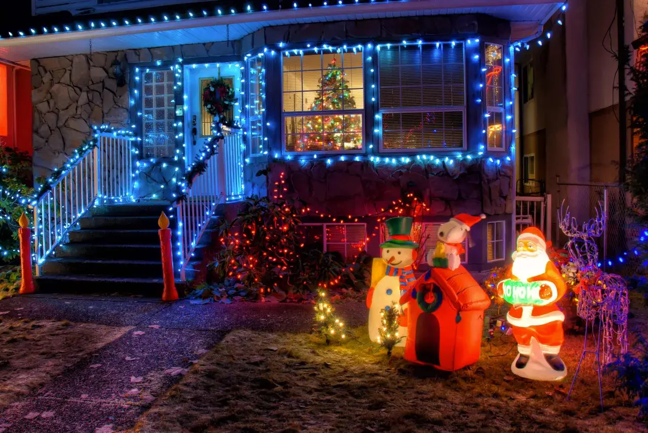 La maison est d&eacute;cor&eacute;e de lumi&egrave;res bleues et rouges, avec un P&egrave;re No&euml;l gonflable, un bonhomme de neige et un renne. C'est l'une des plus belles d&eacute;corations de No&euml;l ext&eacute;rieur.