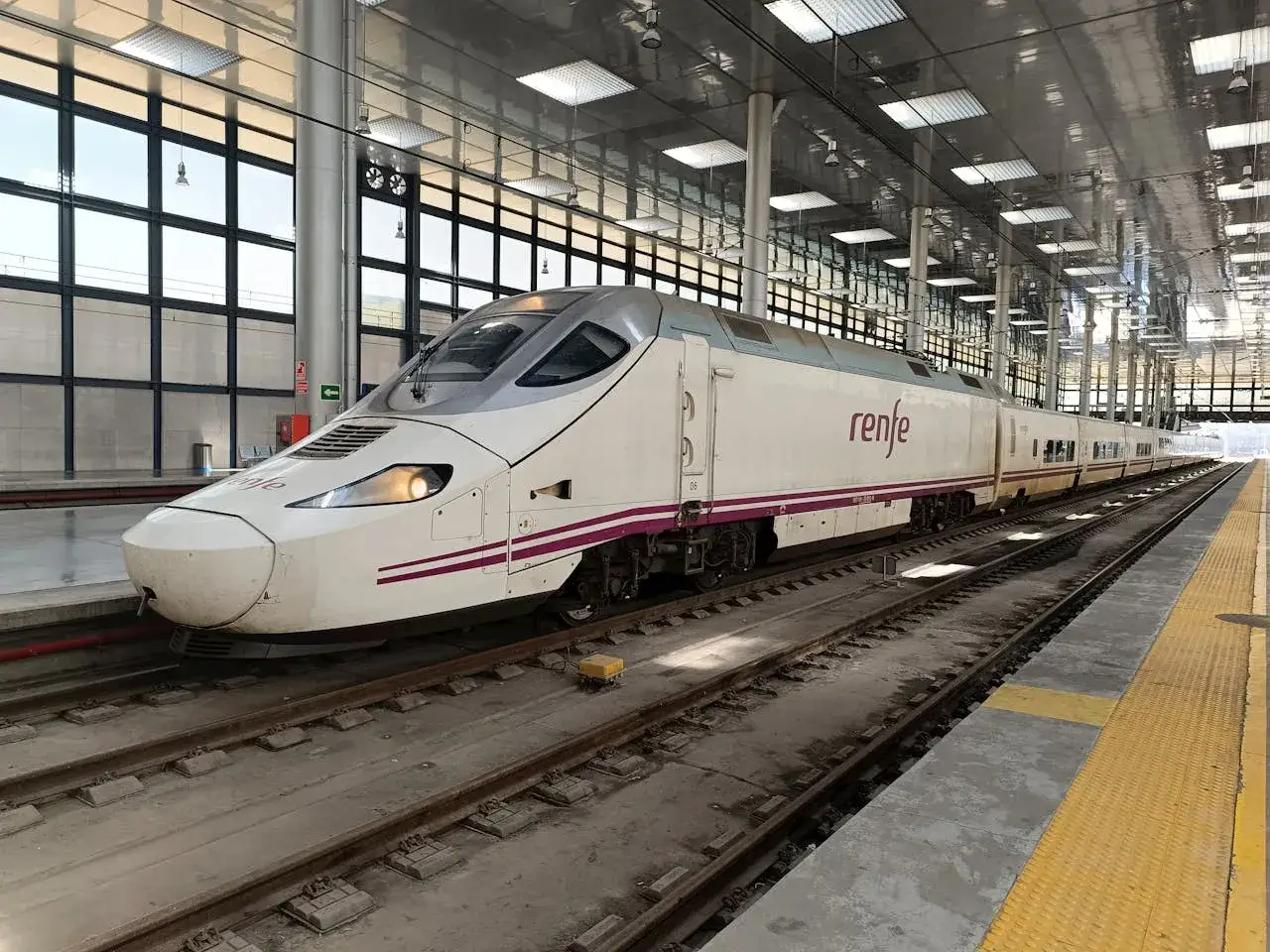 Nowoczesny pociąg Renfe, kolej dużych prędkości, stoi na peronie.