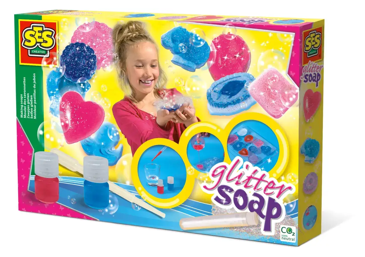 Ein M&auml;dchen lacht und h&auml;lt glitzernde Seifen in Herz- und Tierformen. Das Set 