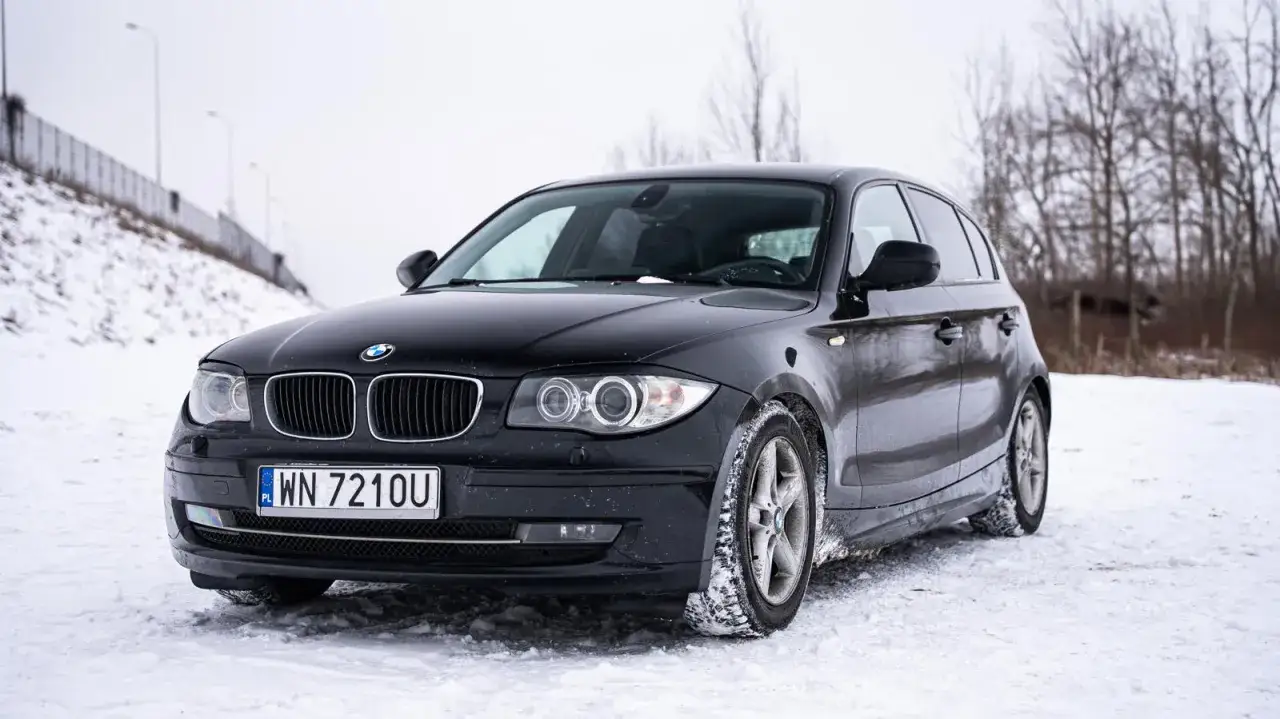 Czarne BMW 118d na śniegu, gotowe na zimowe wyzwania.