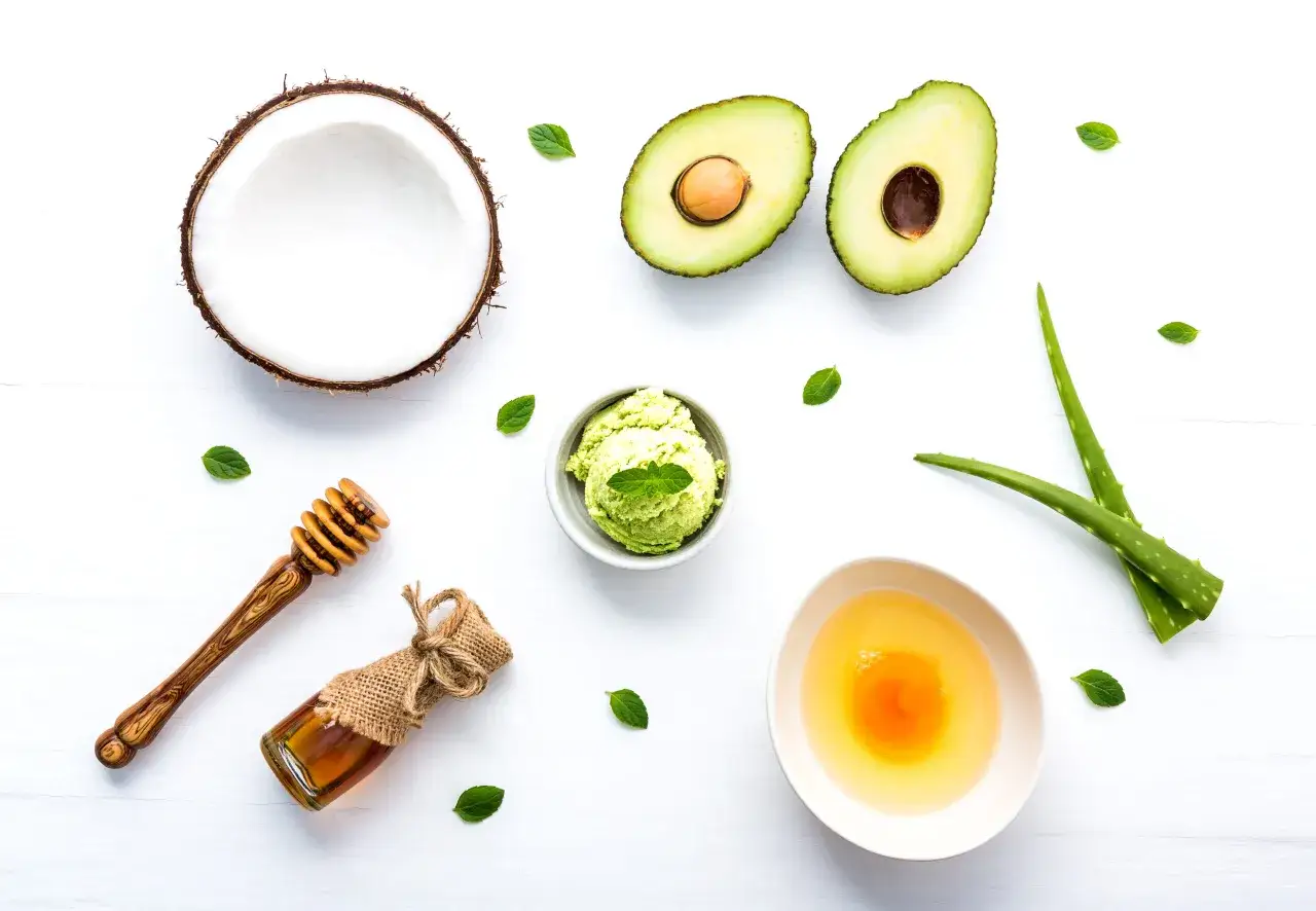 Zutaten für eine natürliche, vegane Haarpflege: Kokosnuss, Avocado, Aloe Vera, Honig und Minze.