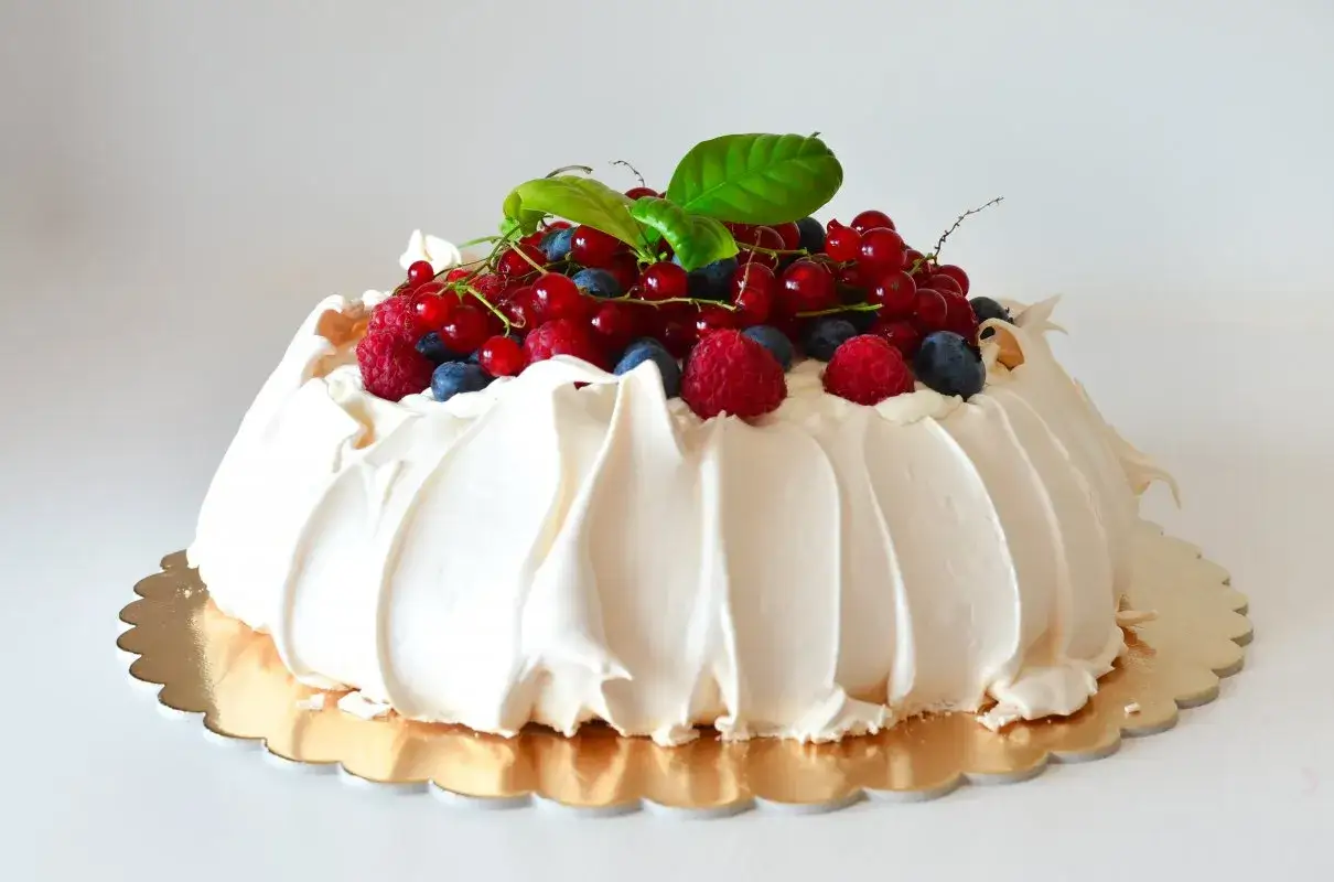 Beza Pavlova, która zawsze wychodzi, ozdobiona świeżymi malinami, borówkami i porzeczkami.