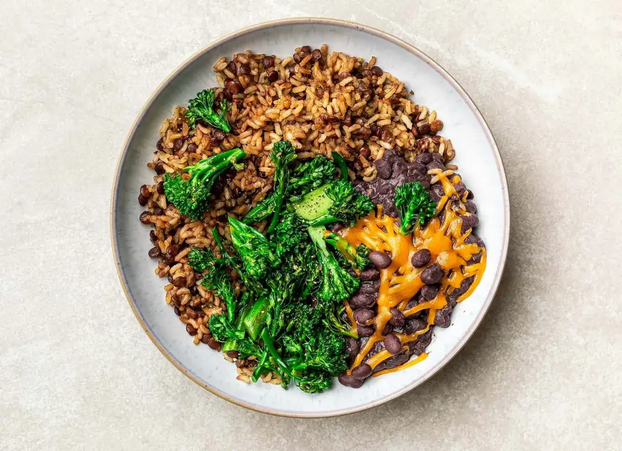Een heerlijke, voedzame maaltijd die laat zien wat is vegetarisch: rijst met linzen, zwarte bonen, broccoli en gesmolten kaas.