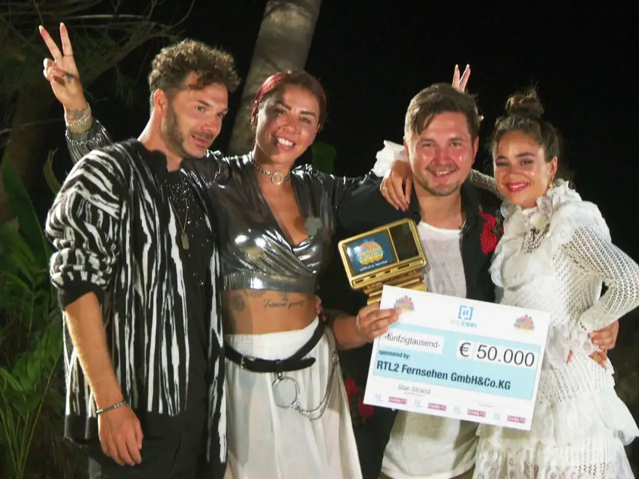 Vier Realitystars feiern ihren Sieg beim Kampf der Realitystars. Sie halten einen Scheck über 50.000 Euro und eine Trophäe. Wer ist raus?