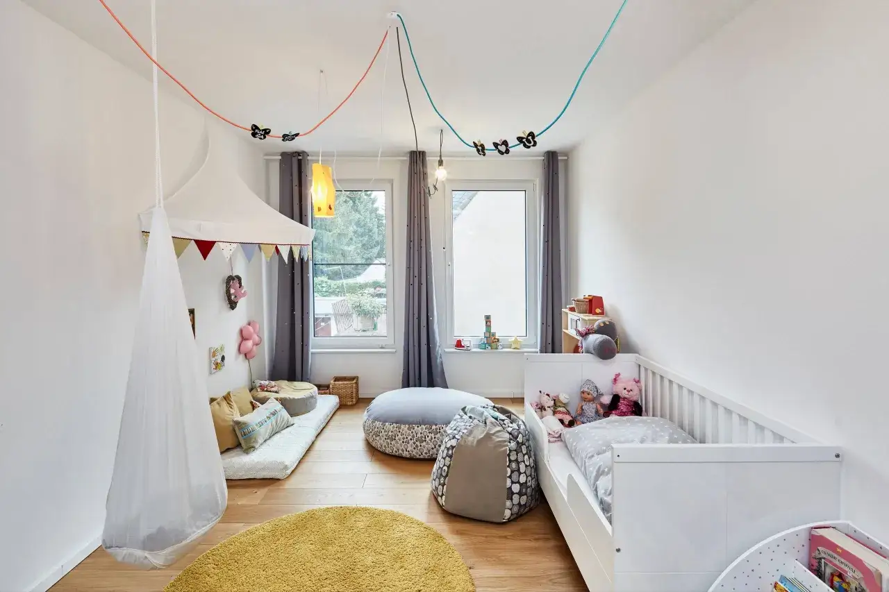 Ein gemütliches Kinderzimmer mit Hängesessel, Spielzeug und Bett. Hier können reizoffene Kinder spielen und träumen.