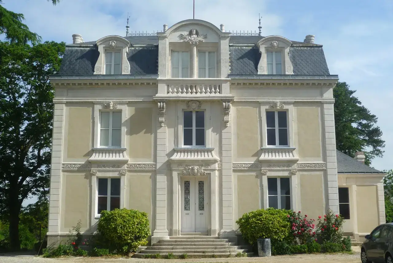 Belle demeure avec un enduit à la chaux extérieur, des fenêtres à croisillons et un toit mansardé.