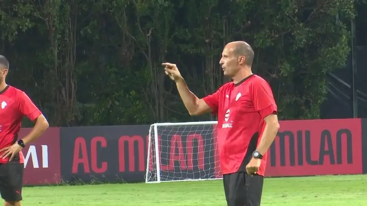 Massimiliano Allegri, w czerwonej koszulce, instruuje zawodników na boisku treningowym AC Milan.