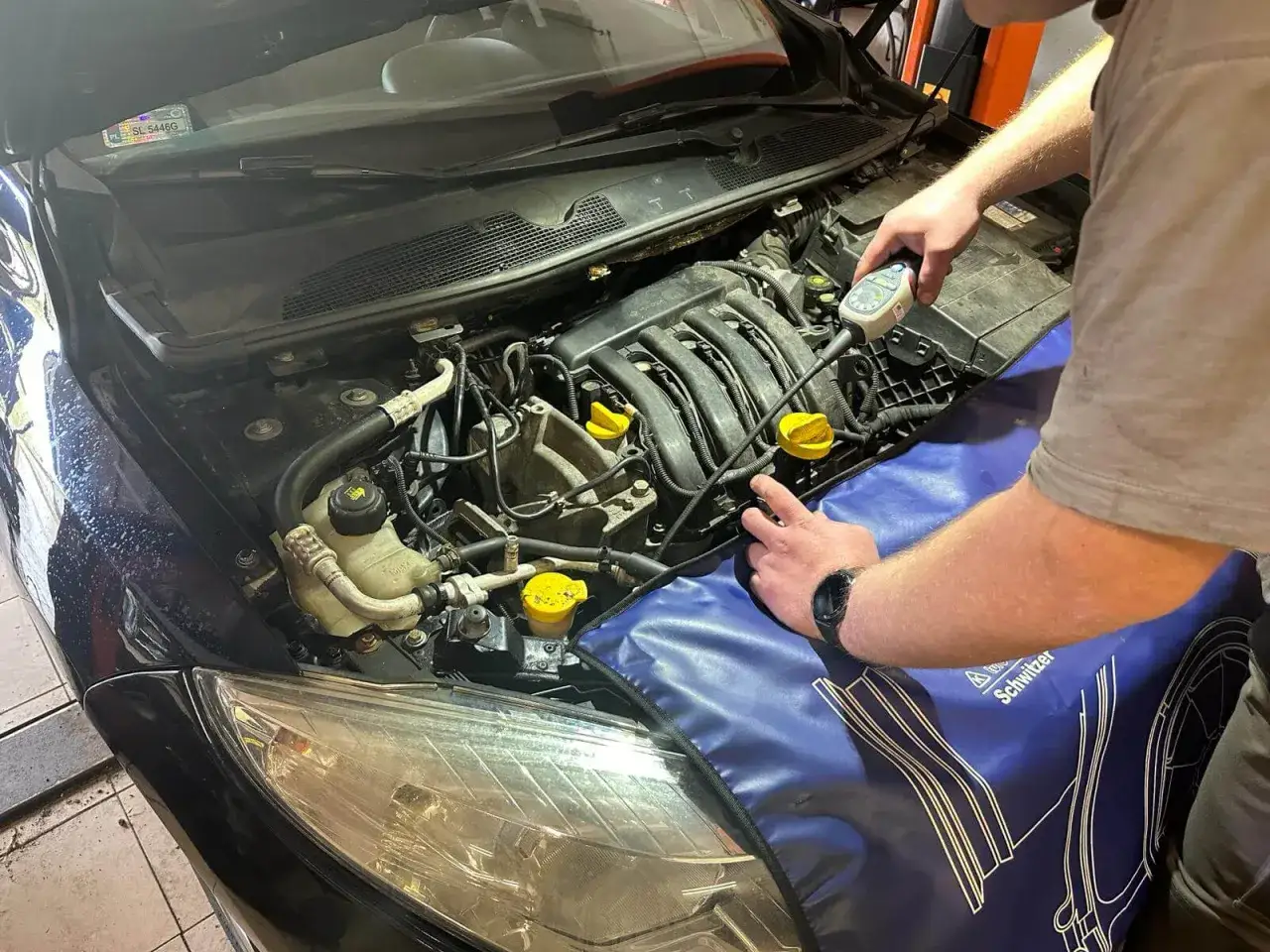 Mechanik sprawdza ciśnienie w układzie klimatyzacji podczas wymiany sprężarki.