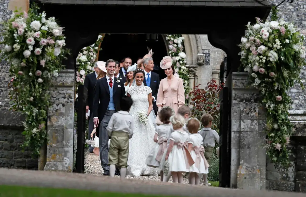 Para młoda wychodzi z kościoła, otoczona przez dzieci w strojach komunijnych. To piękne angielskie wesele, pełne elegancji i radości.