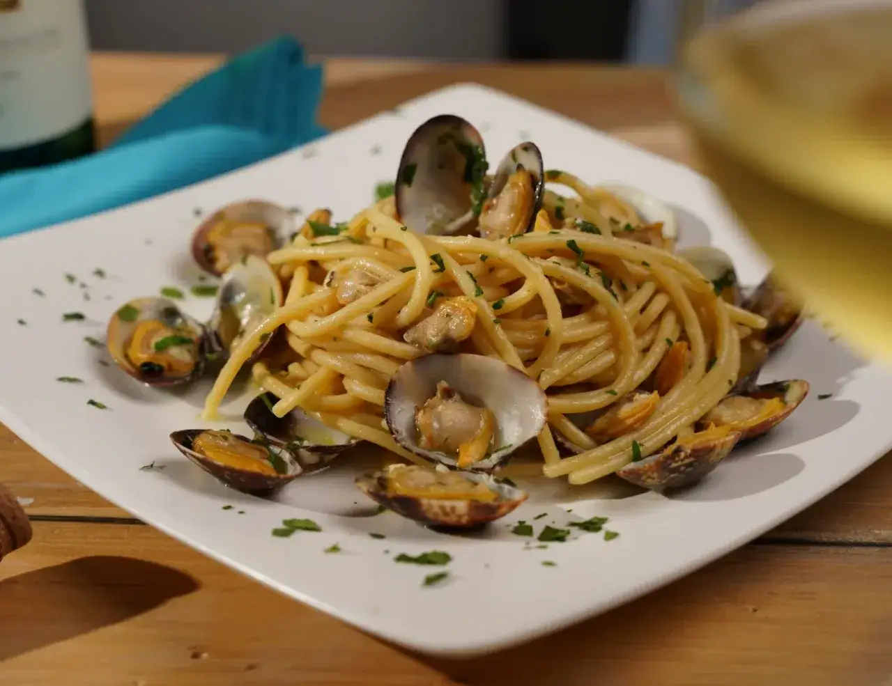 Spaghetti alle vongole fumanti, un piatto di pasta con cozze fresche e prezzemolo tritato, pronto per essere gustato.
