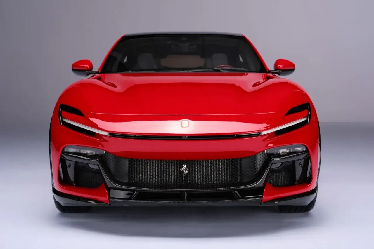 Czerwony Ferrari SUV z czarnym dachem i charakterystycznym grillem z koniem.