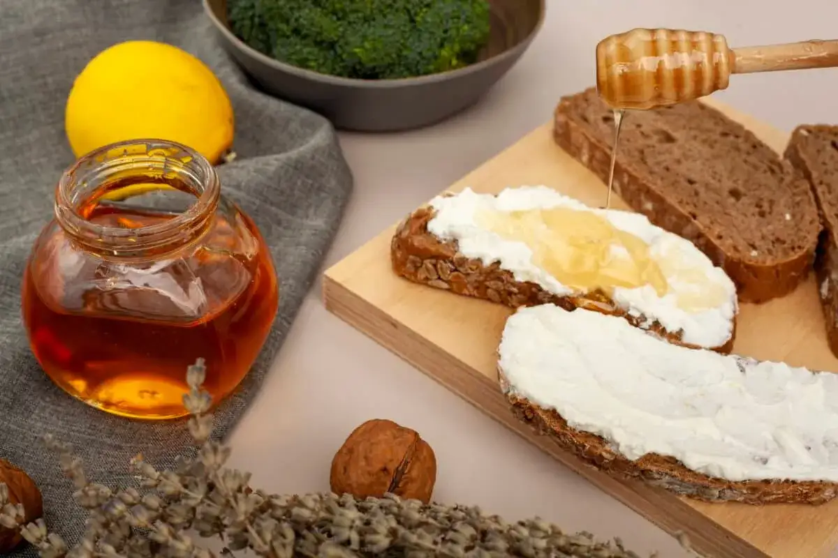 Słoik miodu, cytryna, brokuły i chleb z twarożkiem. Miód a cukrzyca - czy można go spożywać?