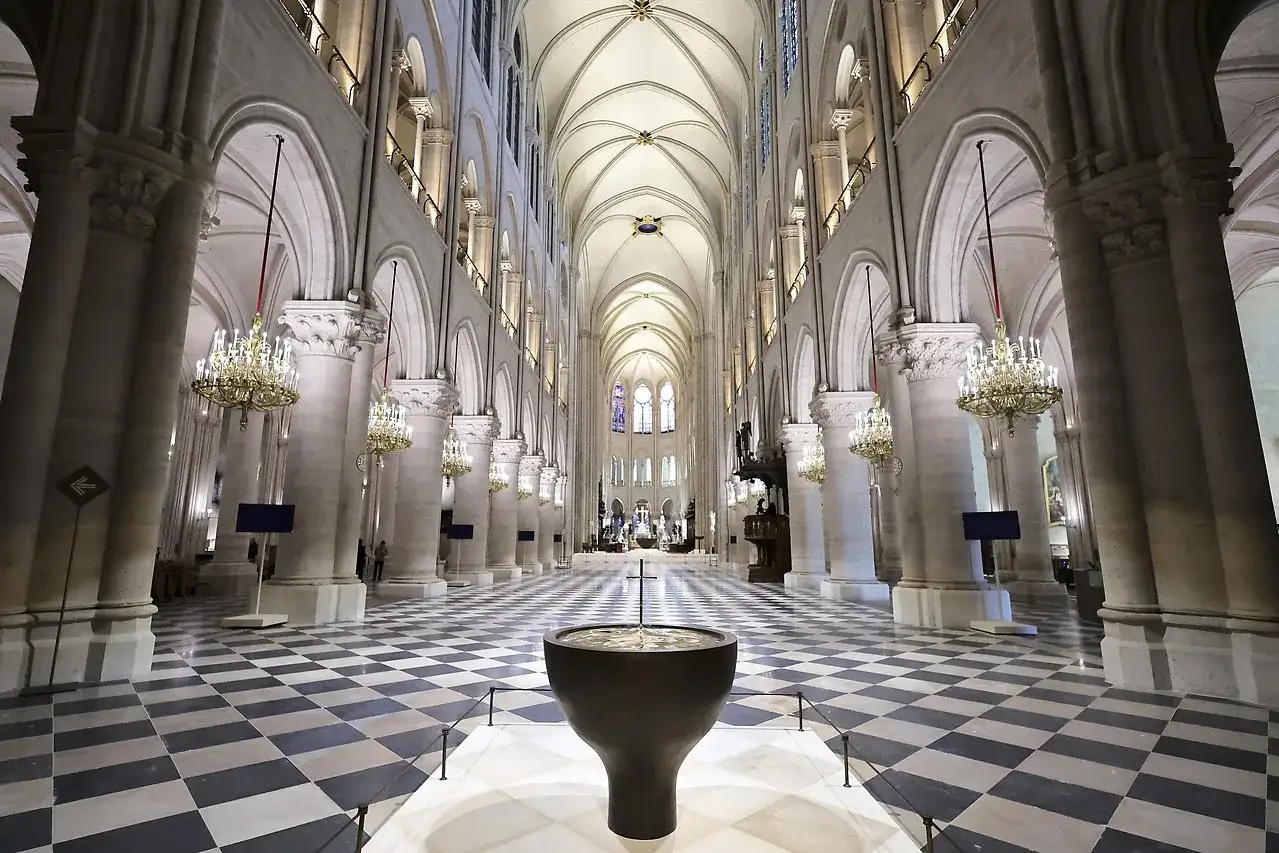 Das Innere der Notre Dame mit ihrem beeindruckenden Kreuzrippengew&ouml;lbe, den S&auml;ulenreihen und dem Schachbrettmuster des Bodens.