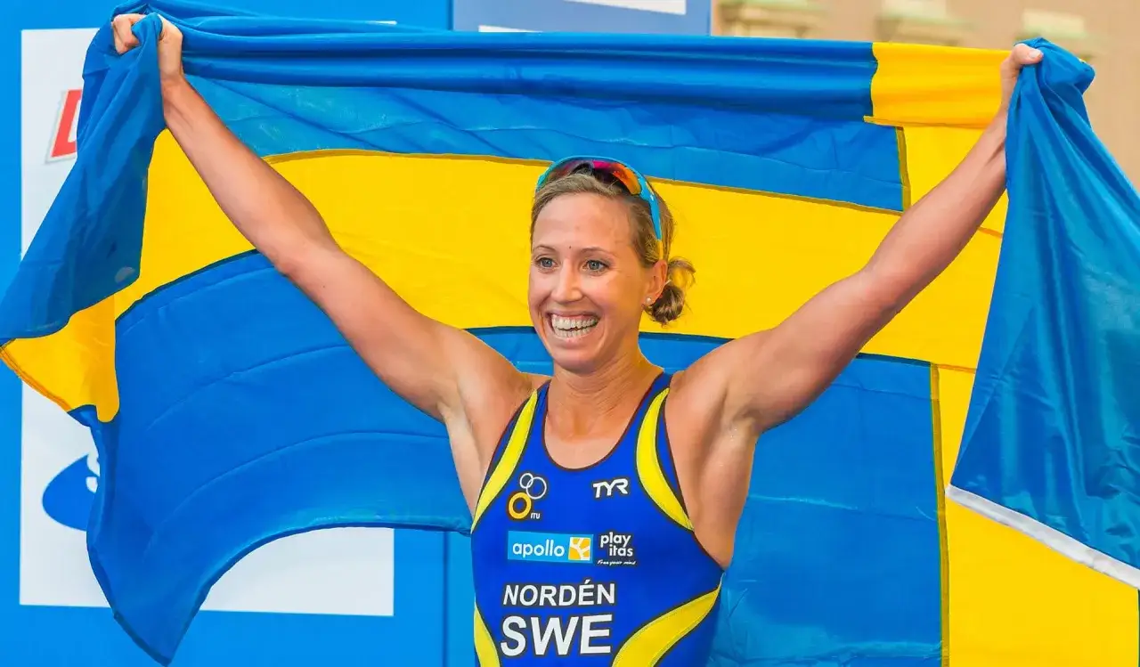 Glad triathlet med svensk flagga efter en framgångsrik tävling i triathlon Sverige.