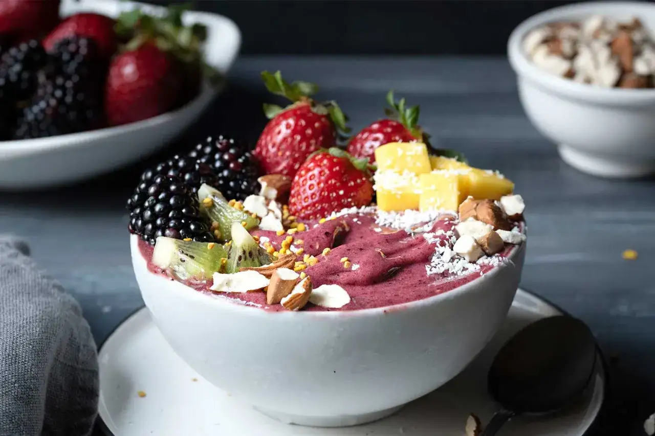 Ein Acai Bowl Rezept mit frischen Beeren, Kiwi, Mango, Mandeln und Kokosraspeln.