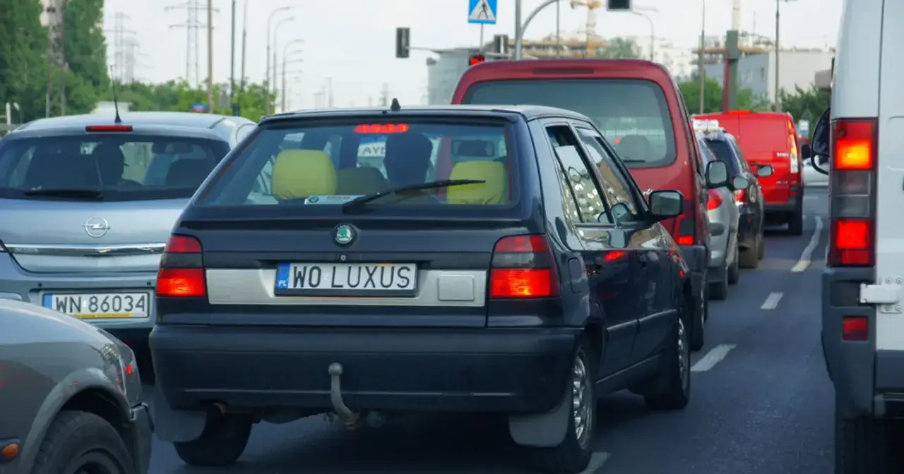 Korek uliczny, gdzie widać samochody z indywidualnymi tablicami rejestracyjnymi, np. 