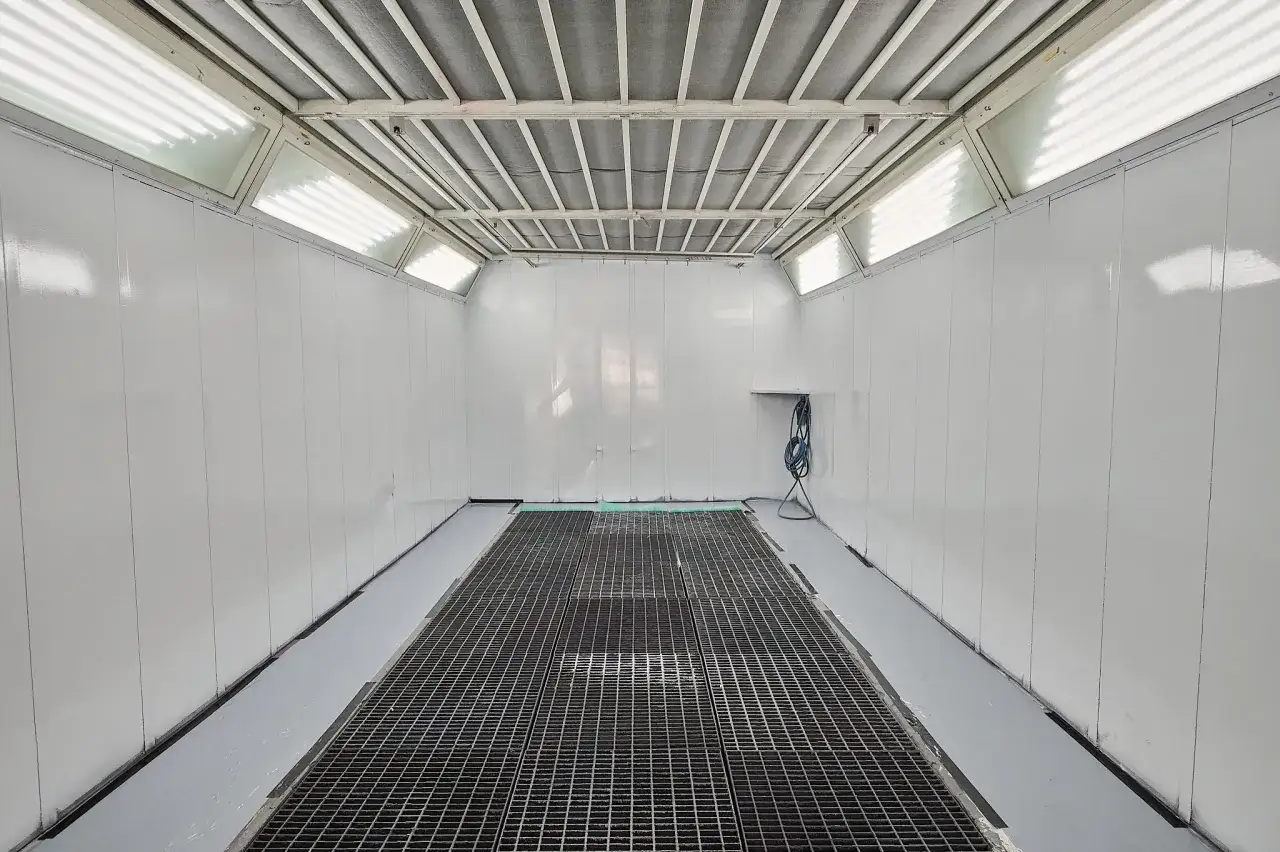 Cabina de pintura lista para un trabajo que vale pintar un coche entero. Iluminación potente y rejilla de drenaje.
