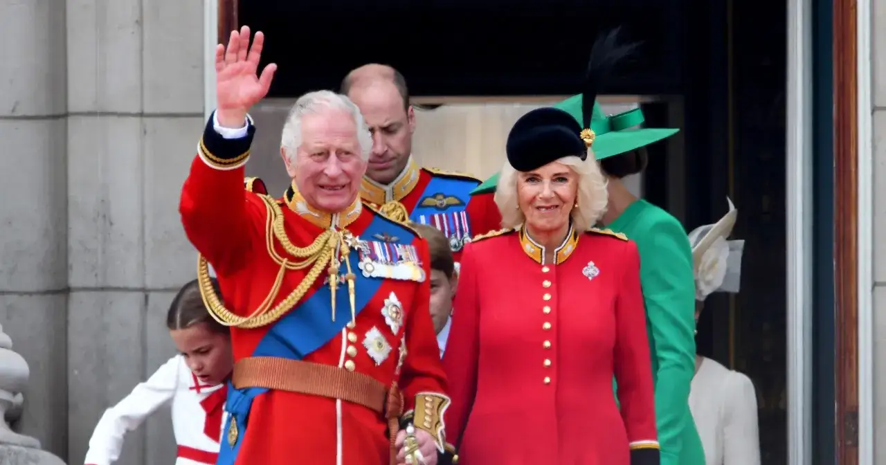 Król Karol i królowa Camilla, z synem Williamem w tle, pozdrawiają tłumy.