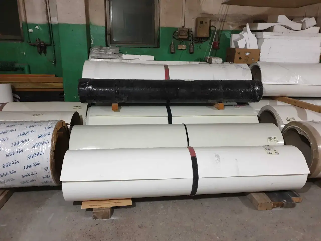 Materiały do naprawy poszycia kampera z laminatu: białe i czarne rolki materiału, gotowe do użycia.