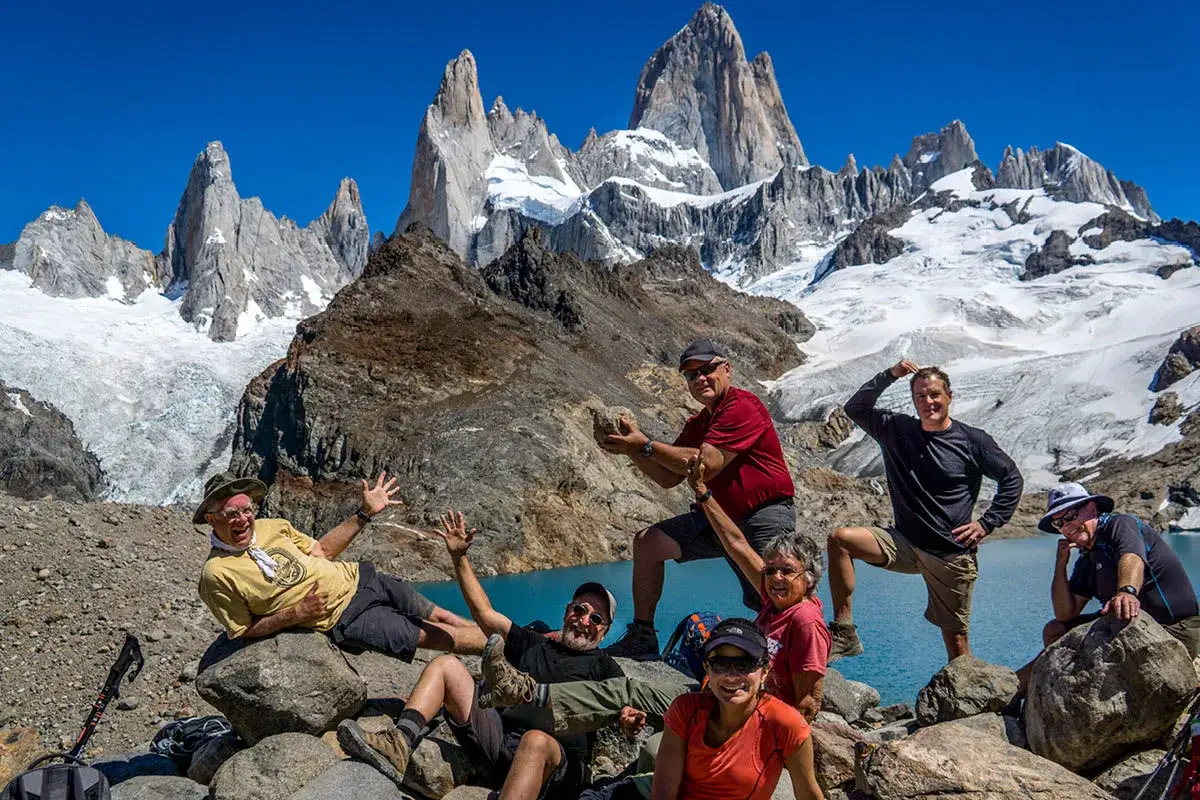 Grupa przyjaci&oacute;ł cieszy się widokiem na Patagonię, w tle majestatyczne g&oacute;ry i lodowiec. To idealne miejsce na przygodę z marką Patagonia.