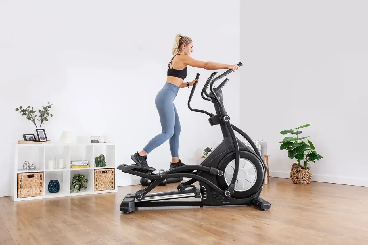 Frau trainiert auf Crosstrainer f&uuml;r effektives Abnehmen.