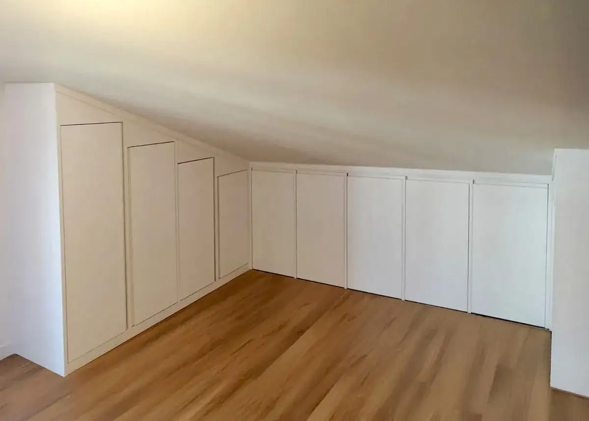 Armadi su misura sfruttano ogni centimetro, perfette idee sottotetto molto basso. Pavimento in legno chiaro.