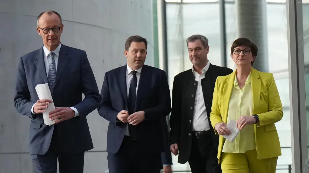 Vier Politiker gehen nebeneinander. Sie diskutieren, was ist Koalition und wie sie die Zukunft gestalten.