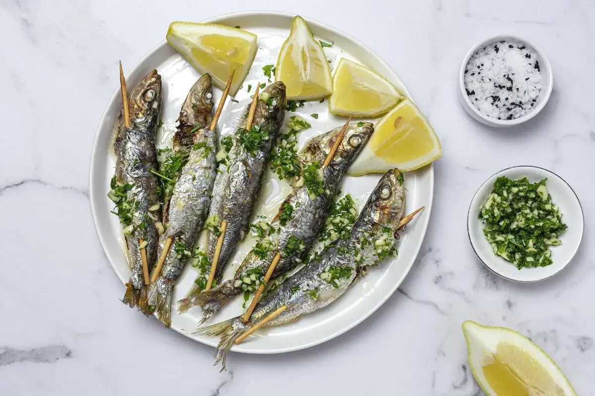 Sardinas al horno en brochetas, con lim&oacute;n y perejil picado. Un plato sencillo y delicioso.