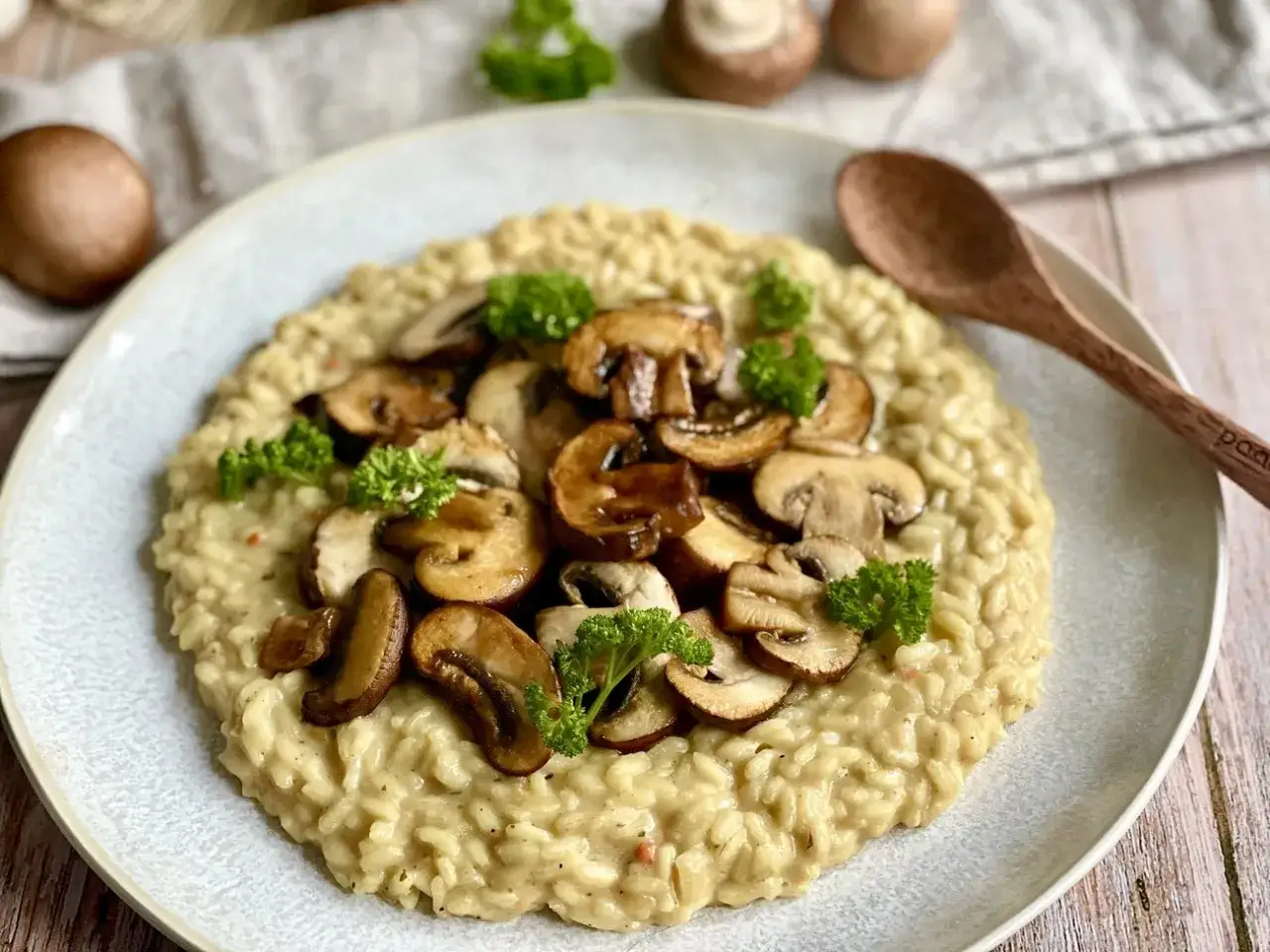 Cremiges veganes Risotto mit gebratenen Champignons und frischer Petersilie garniert. Ein Genuss für alle Sinne.
