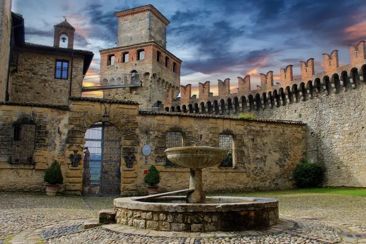 Antico cortile con fontana e mura merlate, un gioiello tra i borghi vicino Parma.