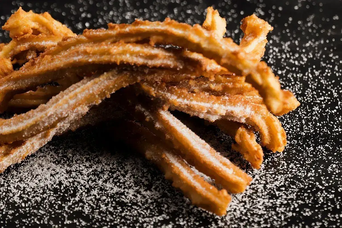 Złociste churros posypane cukrem, idealne do domowego churros przepis. Chrupiące i słodkie.