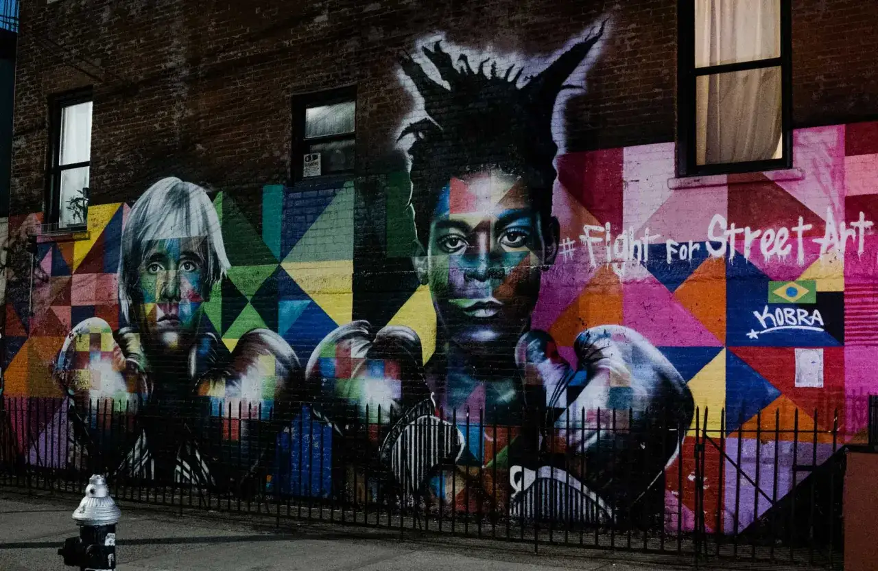 Vibrant mural featuring portraits of two boxers, reminiscent of artists like Basquiat, with bold geometric patterns and the hashtag #FightForStreetArt.