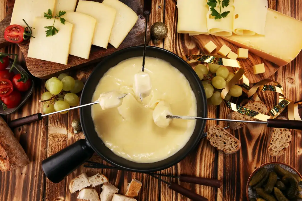 Fondue au fromage, une sp&eacute;cialit&eacute; Rh&ocirc;ne Alpes, avec pain, raisins et tomates cerises.