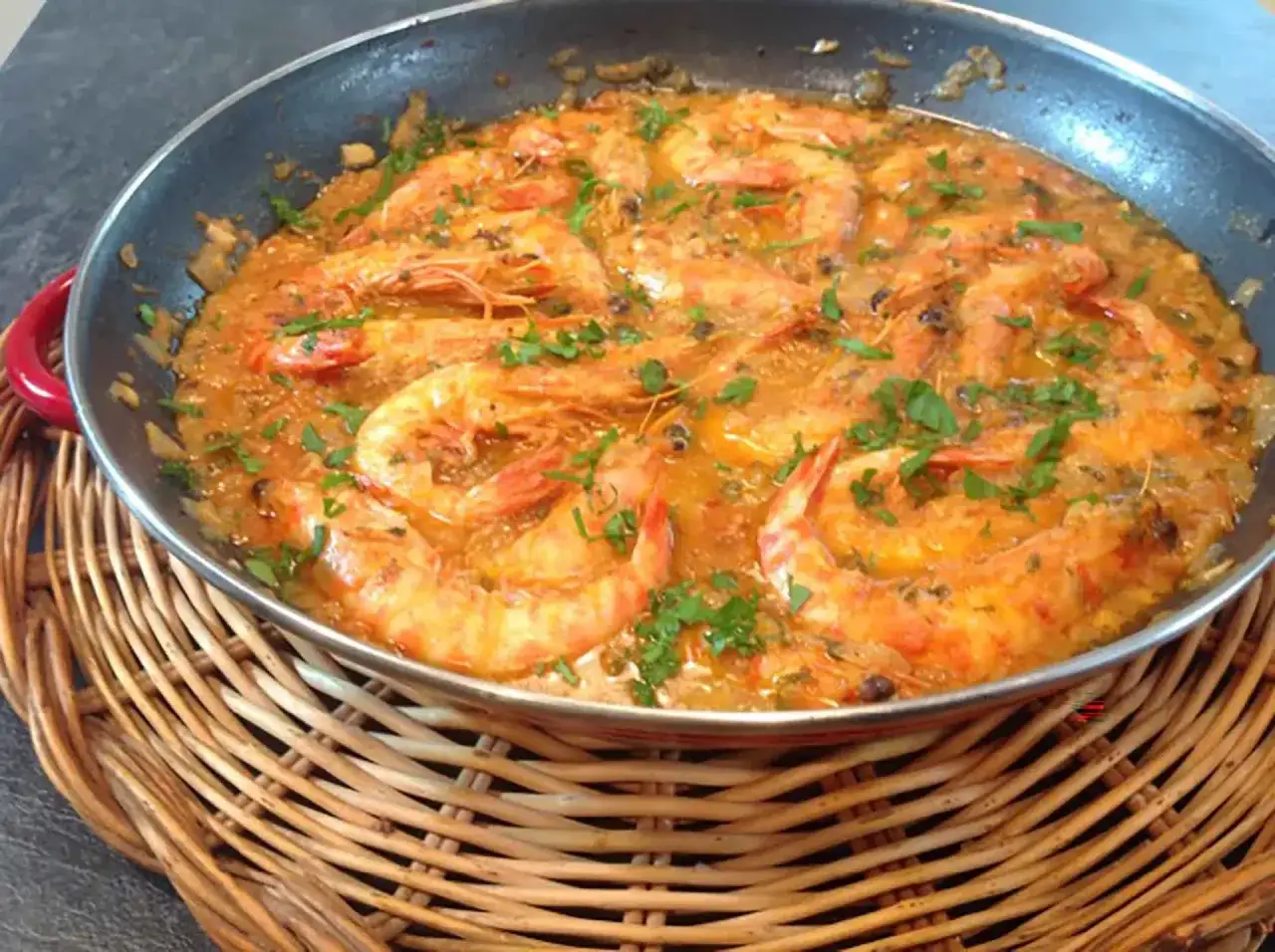 Langostinos en salsa, un plato principal jugoso y lleno de sabor, con gambas rosadas bañadas en una rica salsa y espolvoreadas con perejil fresco.
