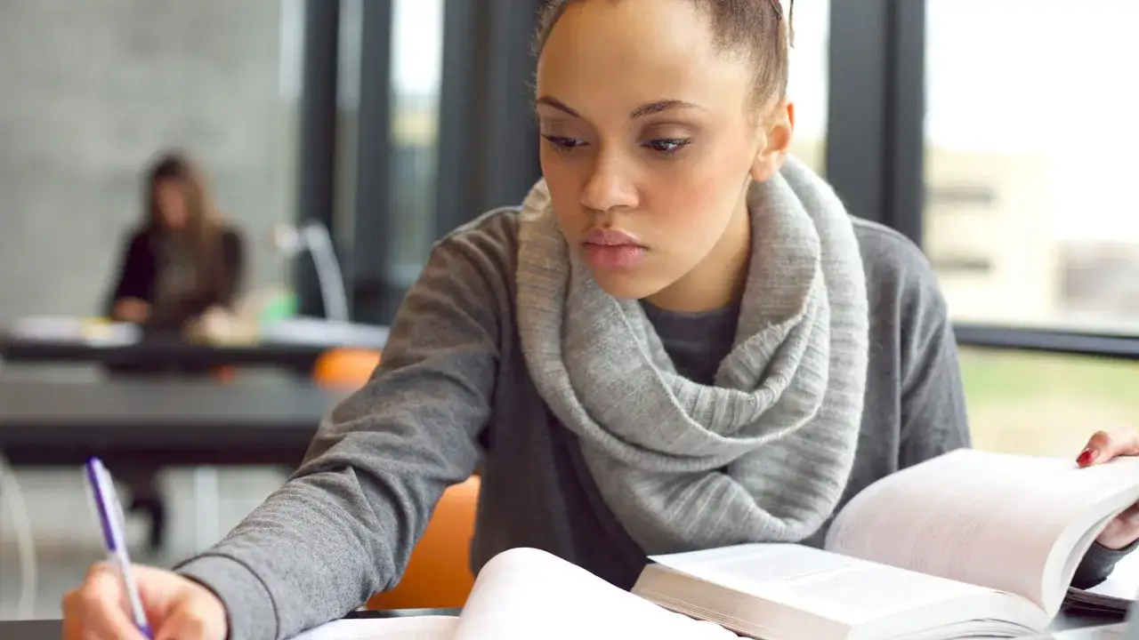 Joven concentrada estudiando, quizás planeando su **gap year** para viajar y aprender.