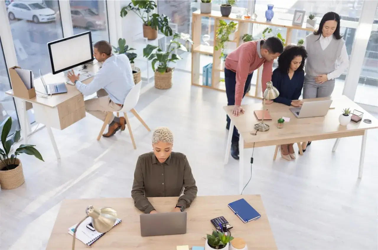 Ufficio moderno con scrivanie ben disposte, seguendo la normativa per un ambiente di lavoro funzionale e collaborativo.