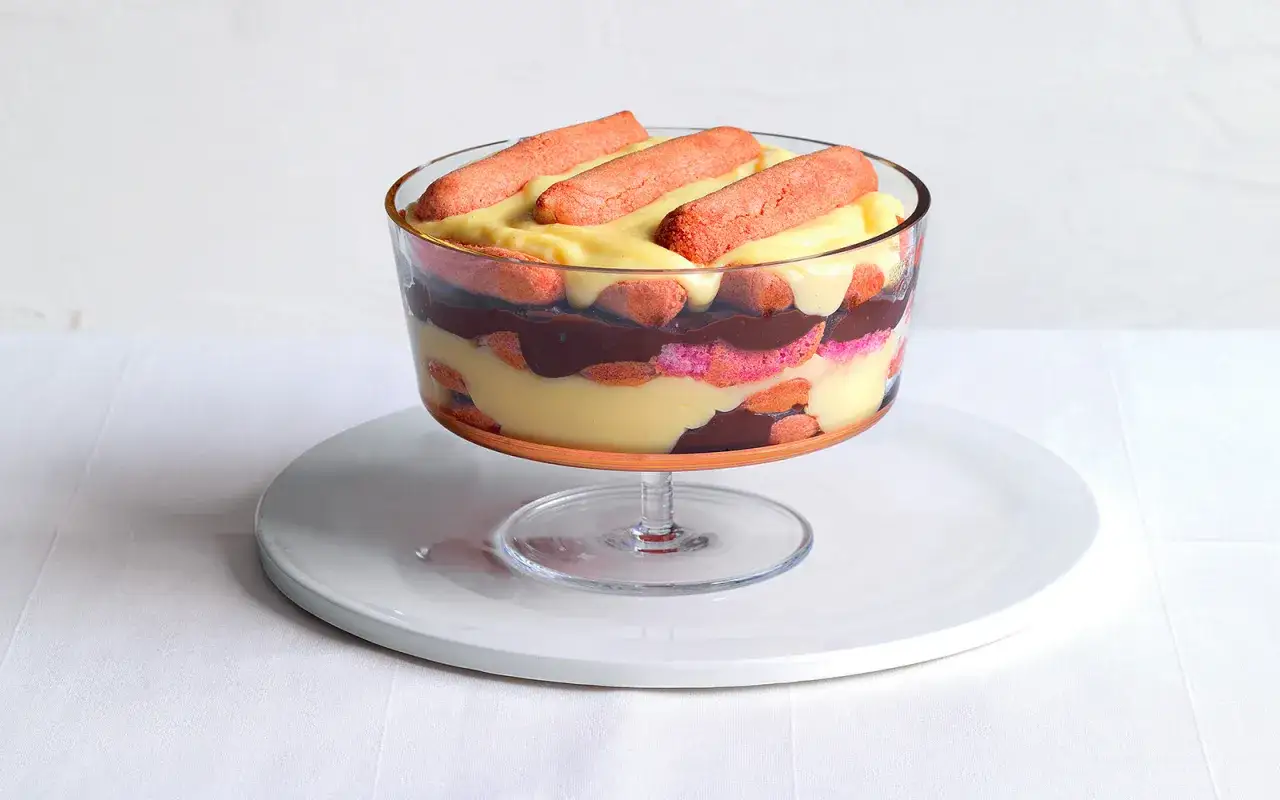 Warstwowy deser w pucharku, przypominający zuppa inglese przepis, z biszkoptami, kremem waniliowym i czekoladą.