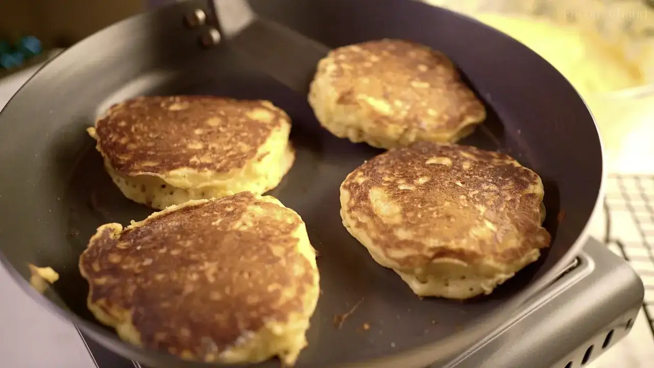 Quatre pancakes dor&eacute;s et moelleux cuisent dans une po&ecirc;le. La p&acirc;te &agrave; pancake est pr&ecirc;te &agrave; &ecirc;tre d&eacute;gust&eacute;e.