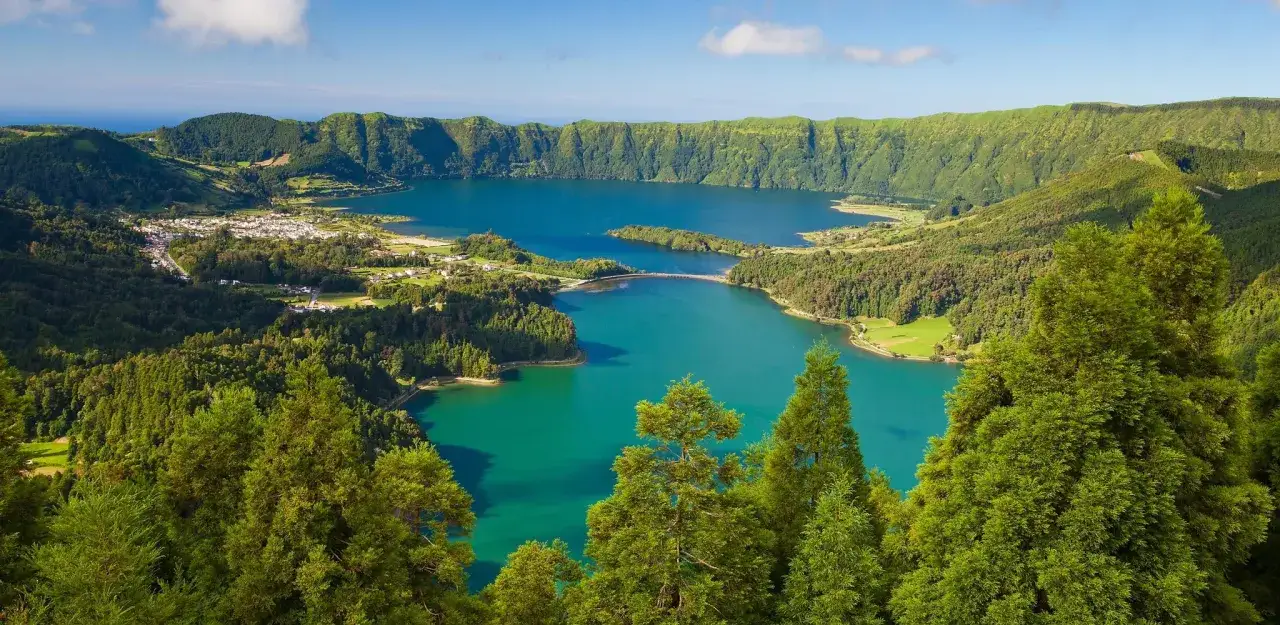 Widok na jezioro Sete Cidades na Azorach. Zielone wzgórza, turkusowa woda i małe miasteczko to idealne miejsca, by zobaczyć.