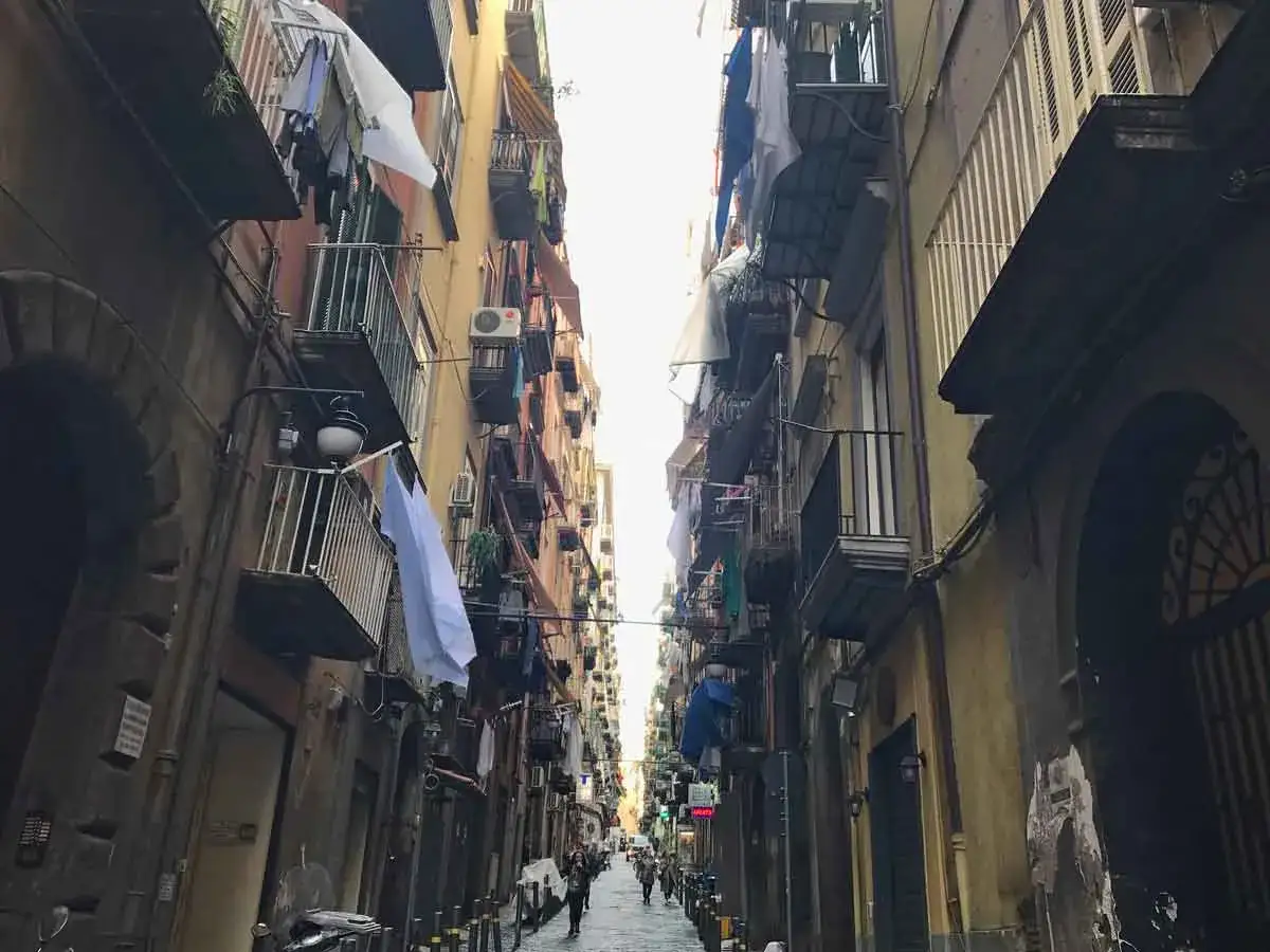 Un vicolo stretto a Napoli centro, con panni stesi ai balconi e scorci autentici da scoprire.