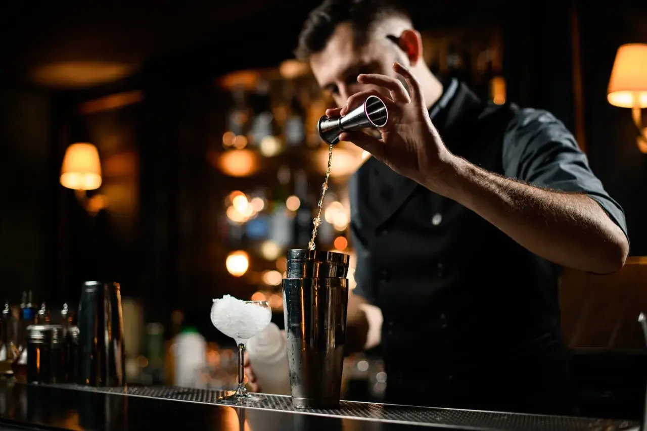 Interno cocktail bar elegante con bartender che prepara un drink