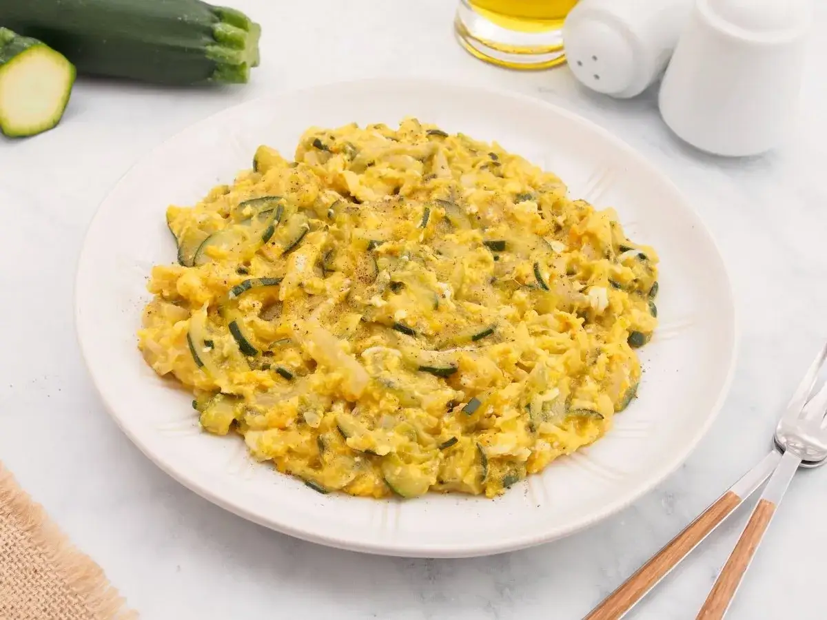 Zarangollo murciano, un plato casero de calabac&iacute;n y huevo, servido en un plato blanco.