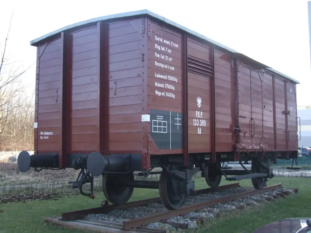 Brązowy wagon towarowy PKP. Na boku widnieje informacja, że waga własna wagonu kolejowego to 9400 kg.