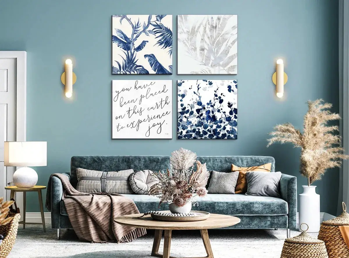 Cuatro cuadros con motivos botánicos y una cita inspiradora crean una decoración de pared de salón original y serena.