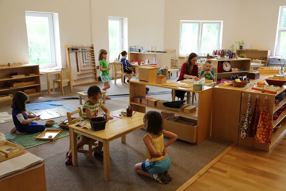 Ni&ntilde;os aprendiendo en un aula Montessori. La educaci&oacute;n Montessori en qu&eacute; consiste: aprendizaje pr&aacute;ctico y auto-dirigido en un ambiente preparado.