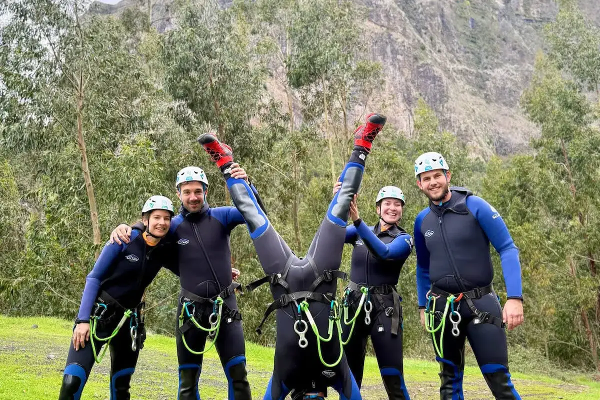Pięć os&oacute;b w piankach i kaskach, gotowych na przygodę. Jedna osoba robi stanie na rękach. To właśnie **canyoning co to** za sport!