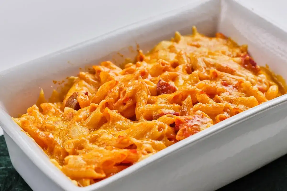 Macarrones con chorizo gratinados en una fuente blanca, listos para disfrutar.